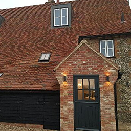 a red brick house with a black barn door