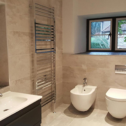 bathroom with toilet, bath and a chrome radiator