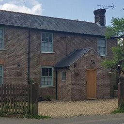 a country house with sage windows and a drive