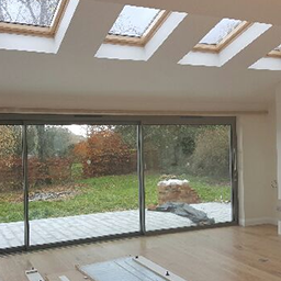 an extension with a glass door and velux windows