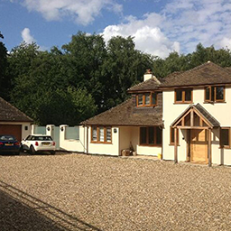 a shingle driveway and white house